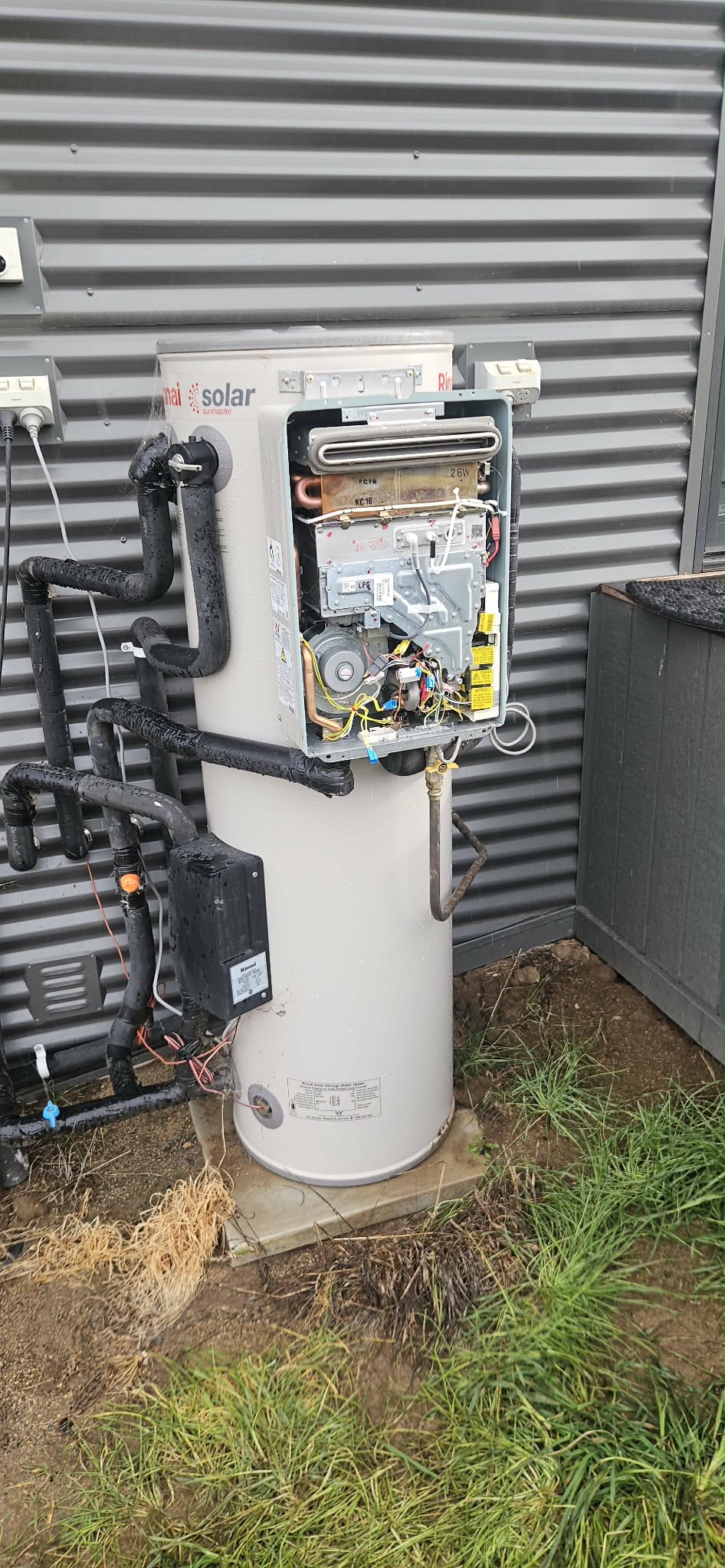 Rinnai solar hot water system with the gas booster opened for servicing.