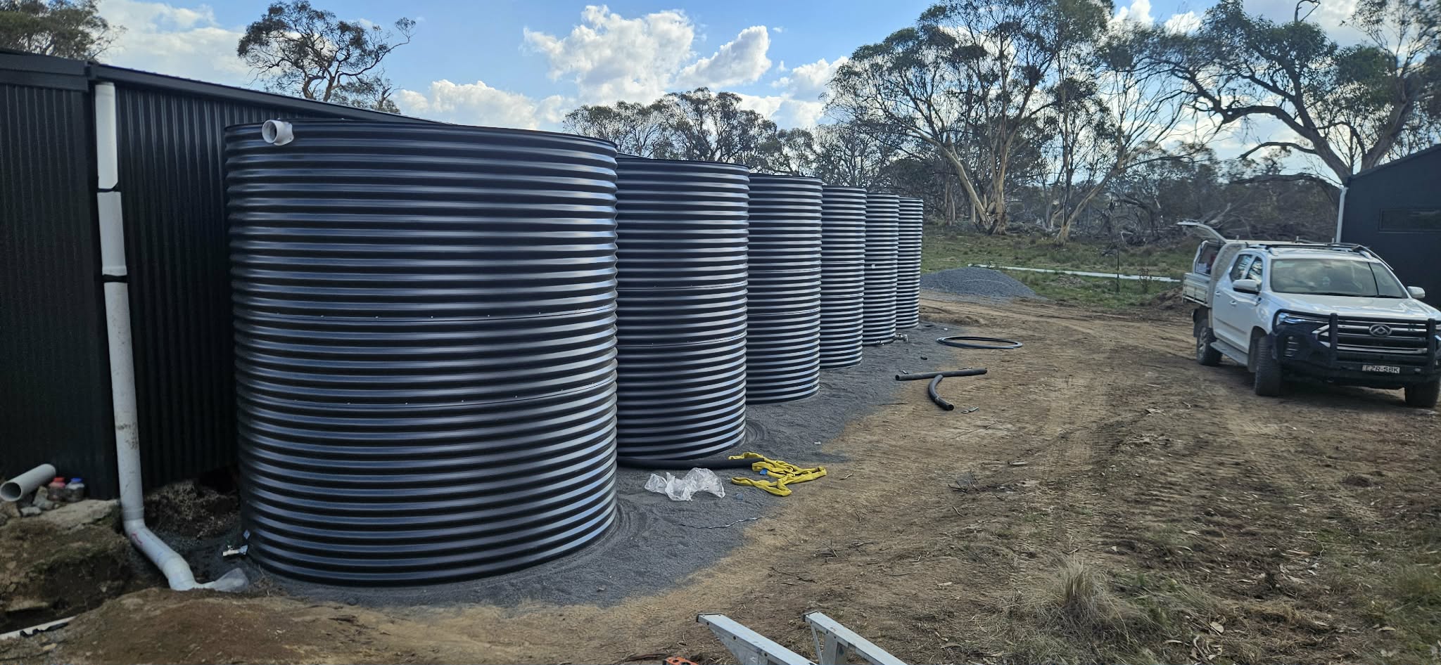 Rainwater tanks installed alongside an outbuilding.